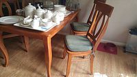 Table top and four chairs arranged with decorative items (not included)