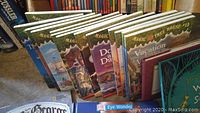 Books from Magic Tree House series and others displayed upright in a box with some titles visible.
