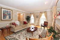 Living room setting featuring the green, burgundy, and beige floral area rug in use for size and color reference.