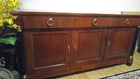 Front view of closed sideboard showing three drawers and three panelled cabinet doors