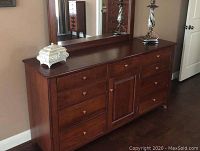 Front view of solid wood dresser with attached mirror