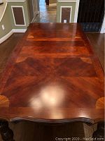 Top view of dining table showing mosaic inlay pattern and wood grain finish