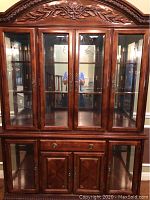 Frontal view showing full upper glass display and lower storage section