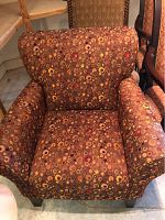 Front angle view of the armchair showing circle-pattern fabric on seat, back, and arms, and wooden legs.
