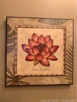 Square wood print with a centered lotus flower illustration in warm tones and framed by bamboo-style border and leafy patterns.