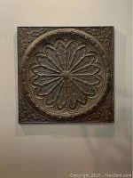 Front view of 48 inch square metal wall art with intricate embossed medallion floral and scroll pattern in dark bronze finish.