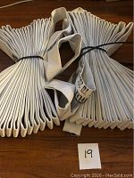 Two bundles of white fire hose, each approximately 50 feet and 1.5 inches wide, neatly folded with loop handles and black cable ties.
