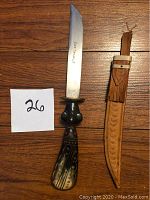 The full knife and sheath laid out on a wooden surface