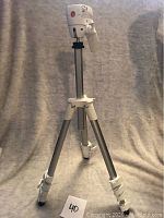 Full view of silver Manfrotto tripod showing extended legs and locking mechanisms.