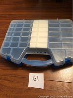 Closed view of the plastic carrying case with compartments for picture hanging hardware.