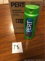 Photo showing one green bottle of Pert Plus Anti-Dandruff 2-in-1 shampoo and conditioner standing in front of the box containing six bottles.