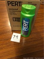 One green bottle of Pert Plus Anti-Dandruff 2-in-1 shampoo and conditioner in front of a cardboard box showing the Pert Plus brand and product details.
