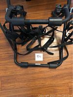 View of the bike rack showing black metal frame and nylon straps.