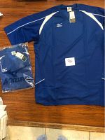 Photo showing one blue Mizuno men's volleyball shirt laid flat and one shirt packaged in plastic, both with tags.