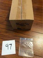 Closed brown cardboard box labeled RONCO Zip with one clear 3x3 inch zip lock bag in front.