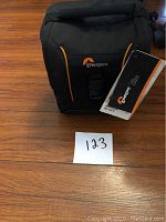 Front view of Lowepro Adventura SH 140 II camera bag with tags and logo clearly visible.