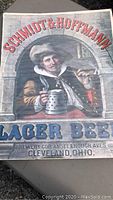 Full view of the vintage Schmidt & Hoffmann beer advertising poster showing the man with a beer stein and text