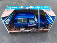 Front and left angle view of Nylint Metal Muscle Bronco toy truck in original box showing blue truck, wheel details, and box graphics.