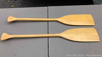 Two light-colored wooden child's canoe paddles, 35 inches long, laid flat side by side showing their full lengths and blades.