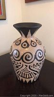 Front view of the tall ceramic vase showing traditional Lenca black painted designs on light beige body.
