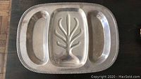 Top view of silver-tone metal serving platter showing three compartments and decorative relief design.