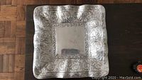 Full view of square pewter tray with decorative edges and blank center