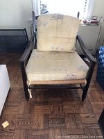 Front view of the armchair showing the wooden frame, seat cushion, and back cushion with floral pattern.