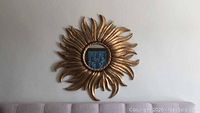 Front view of the sunburst mirror hung on wall