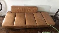 Top-front view of caramel leather sofa cushion showing padded sections and back cushion