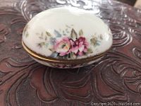 Closed view of the oval bone china accent egg box showing floral patterns and gold rim