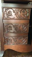 Front view of desk showing three carved floral scroll drawers