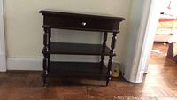 Front view of the solid mahogany accent table showing a single drawer and two shelves beneath.