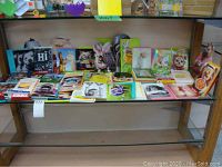 Full view of multiple greeting cards arranged on a metal shelf, featuring dogs, cats, rabbits, and birds.
