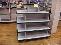 Front view of the display shelf showing four wide shelves with black edge trim.