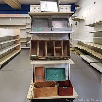 Display of metal bins on top shelves and wooden multi-section organizer in middle with various wooden boxes and trays below.