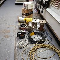 overview of multiple spools of yellow, black, white, silver and copper wire on workshop floor