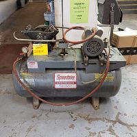 Front-side view of compressor showing motor, pump and yellow note reading “2HP 208 V”