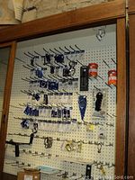 Pegboard display of packaged stainless steel fittings including snap shackles, D-shackles, pad eyes and quick-release hooks