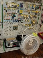 Wide pegboard display showing multiple packaged light bulbs and stainless marine hardware hooks
