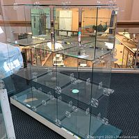 Two assembled glass shelving display units in showroom environment