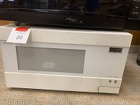 White Sharp Carousel microwave oven with visible digital display and control buttons, placed on the floor.