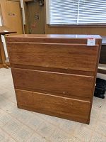 Photo of the entire wooden dresser showing three drawers and overall shape.