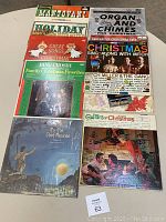 Photo showing 10 vintage Christmas vinyl albums arranged on a table, including Mantovani, Bing Crosby, and Mitch Miller albums with festive covers.