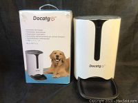 Box with branding and photo of dog next to the automatic pet feeder unit, showing model and product info.