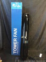 Senville brand blue box labeled 'Tower Fan' beside black tower fan standing upright.