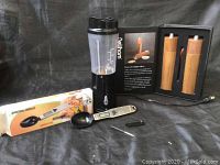 Photo showing all items in the lot including the black bullet blender, digital spoon scale with black scoop and small tool, and the wooden Acacia salt and pepper mill set in box.