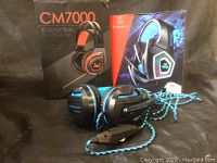 Two Ovann gaming headsets with original product boxes behind them on a black surface.