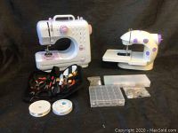 Two portable sewing machines and assorted sewing accessories including tools and thread spools