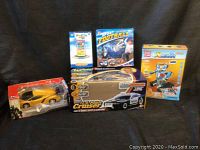 Photo showing all items together including boxes for the police cruiser toy car, sport football game, robot toy, yellow sports toy car, and other smaller boxed toys.