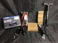 Packaged Lexin LX-B4FM Motocom Bluetooth headset box, Soko Nike motorcycle mirror box, bicycle pump, and various accessories laid out on black cloth.